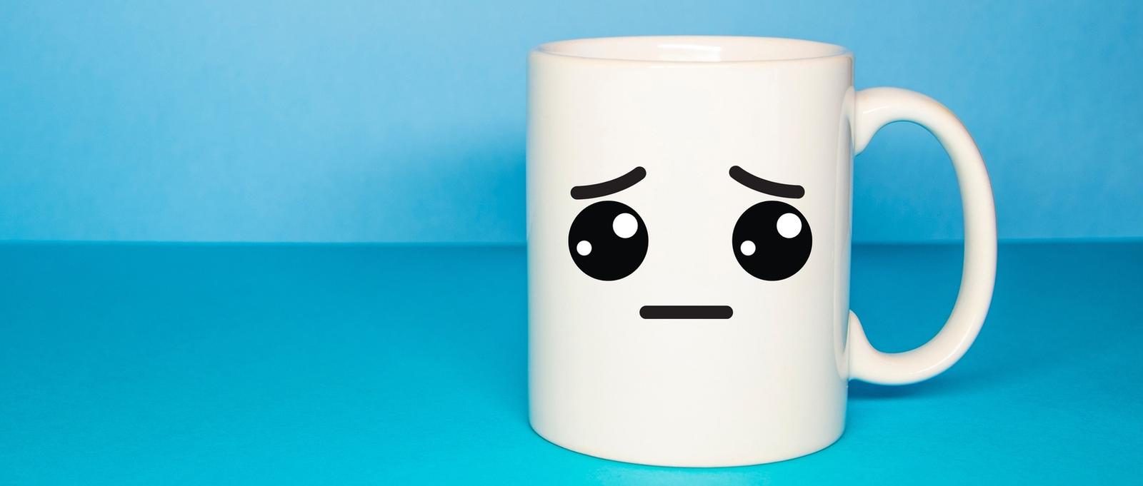 Taza azul con un smiley triste