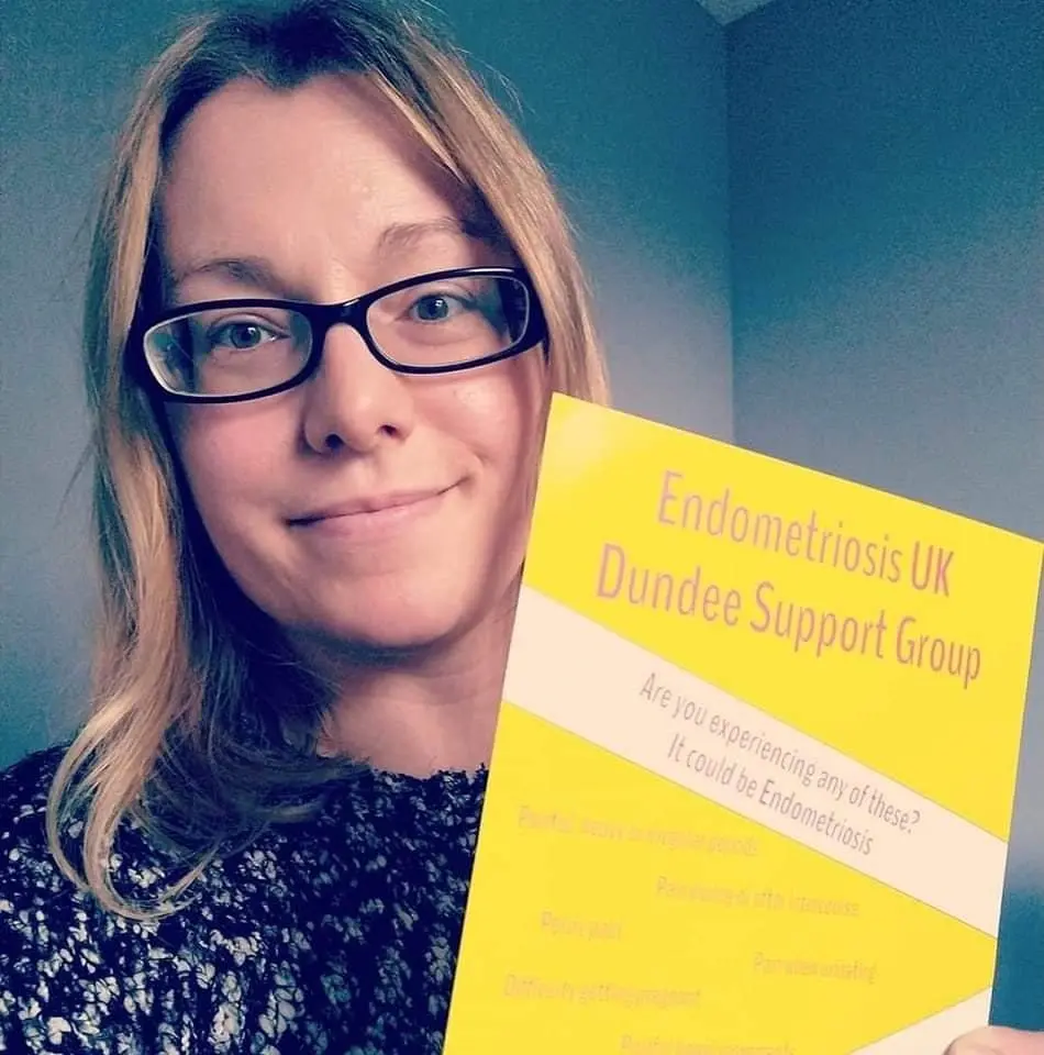 Foto de Vicky sosteniendo un cartel de "Endometriosis UK Dundee Support Group".