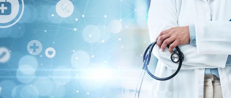 Profesional sanitario con bata blanca sosteniendo estetoscopio sobre fondo médico digital azul con iconos de red.