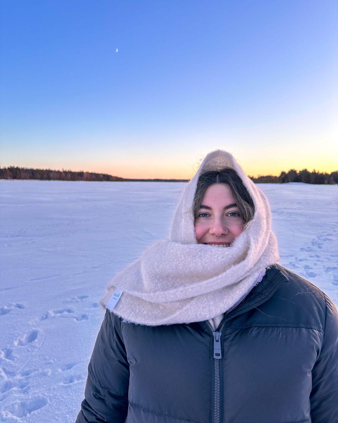Mujer joven con ropa de invierno sobre un fondo nevado.