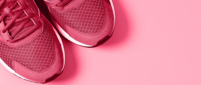 Vista superior de unas zapatillas de color rojo rosado sobre fondo rosa