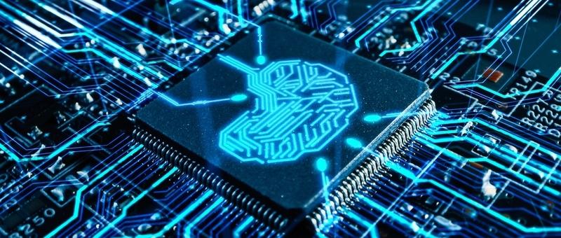 Chip de ordenador con patrón de circuito en forma de cerebro azul brillante sobre fondo oscuro de placa de circuito.