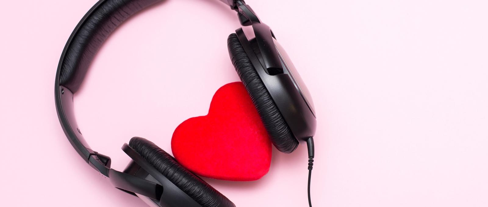 Headphones and heart on pink background