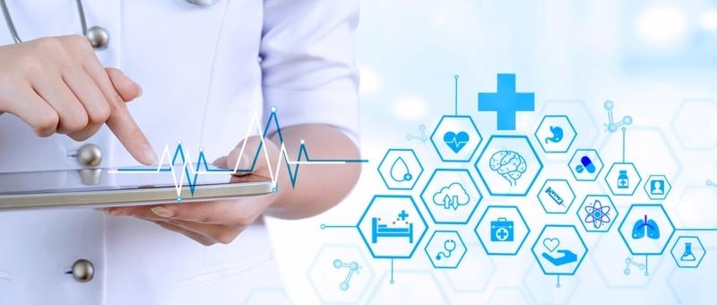 Profesional sanitario utilizando tableta con iconos médicos digitales y gráfico lineal de latido cardíaco en azul.