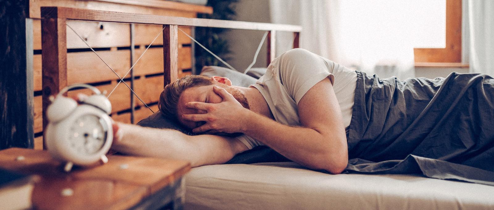 Hombres en la cama con aspecto cansado