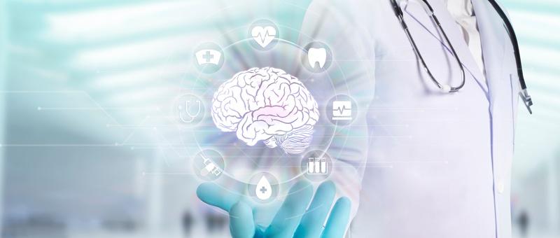 Profesional médico con guantes mostrando holograma digital del cerebro rodeado de iconos sanitarios sobre fondo azul claro.