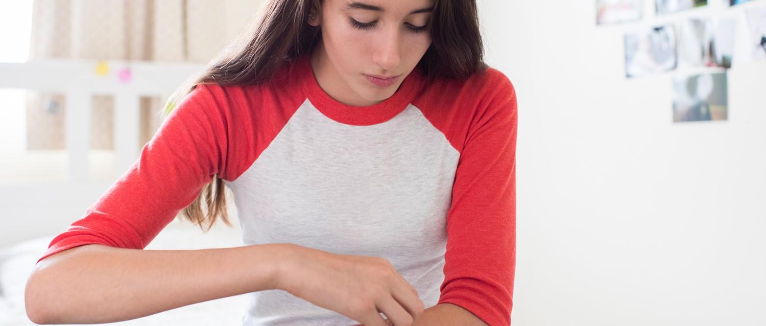 Woman scratching arm