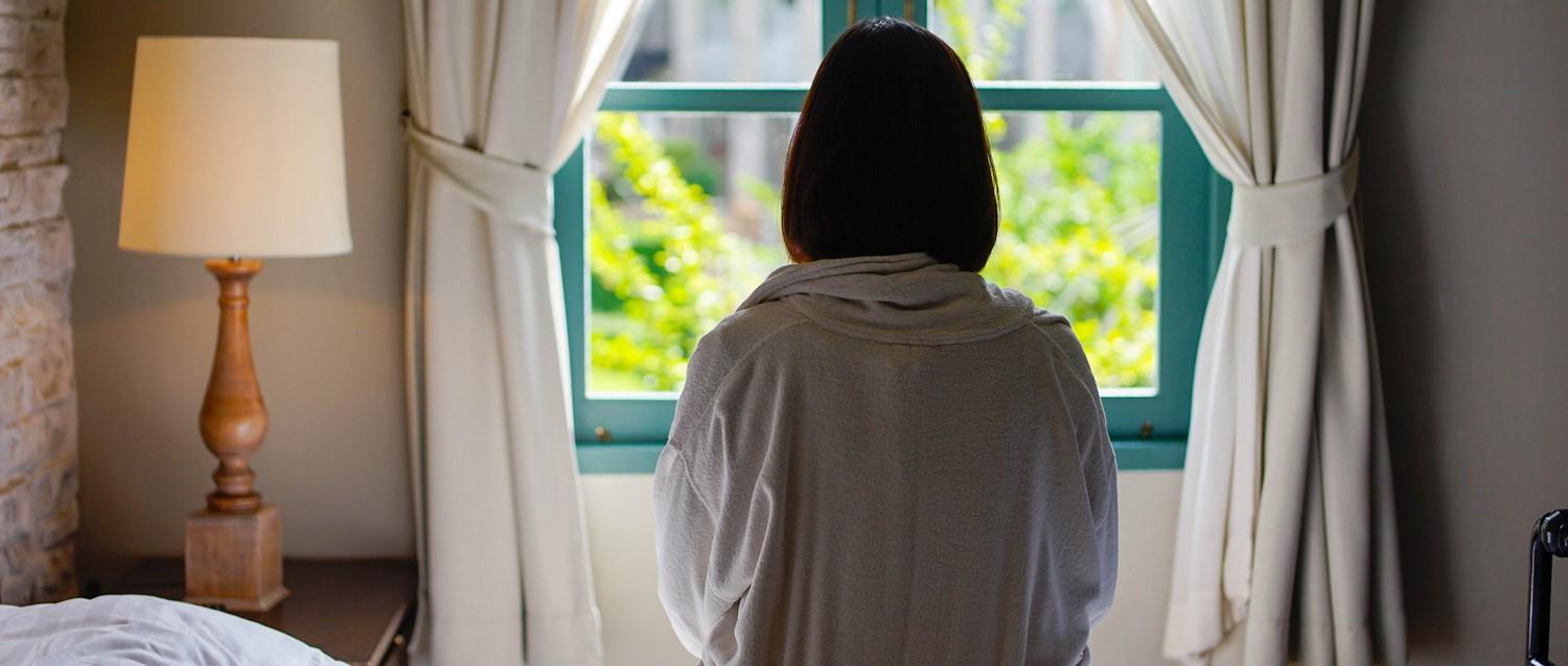 mujer triste mirando por la ventana