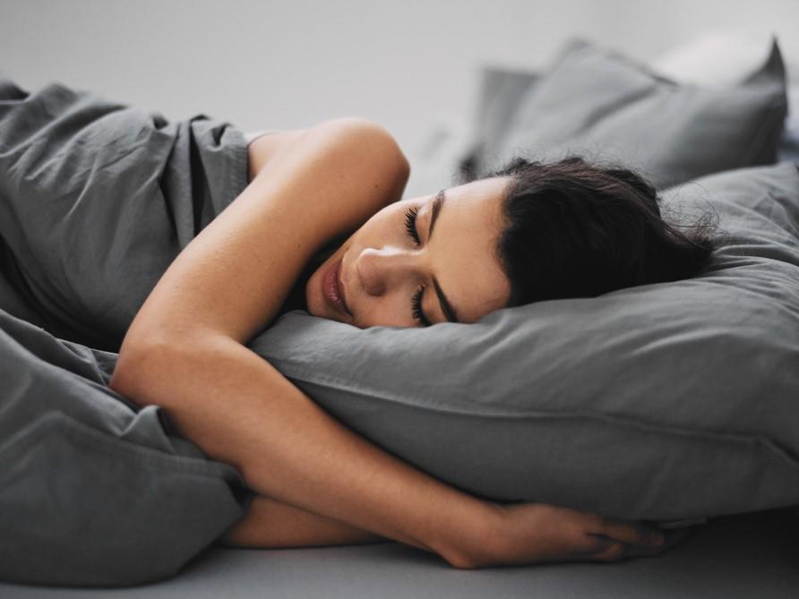 mujer durmiendo en cama gris
