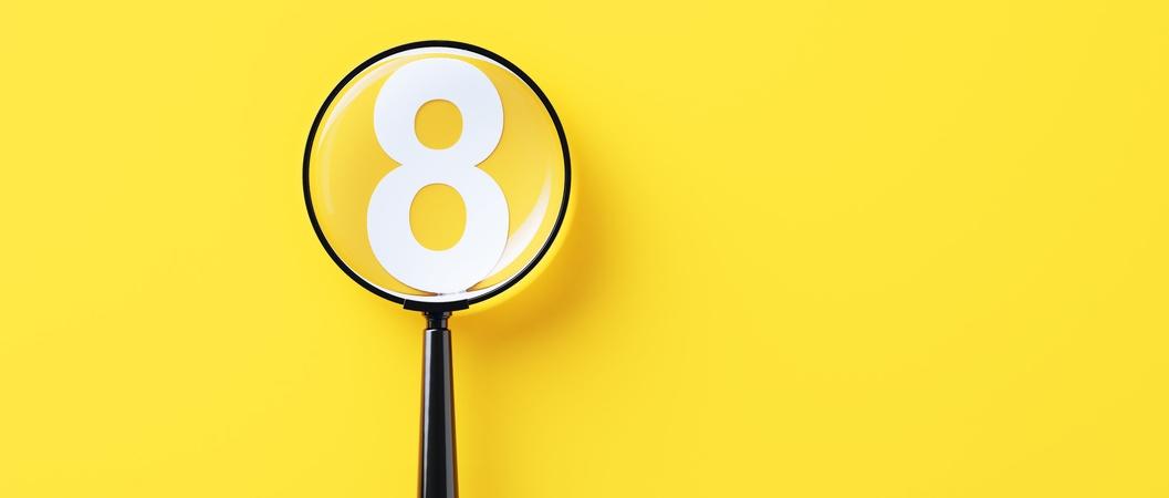 Lupa negra y número ocho blanco sobre fondo amarillo.